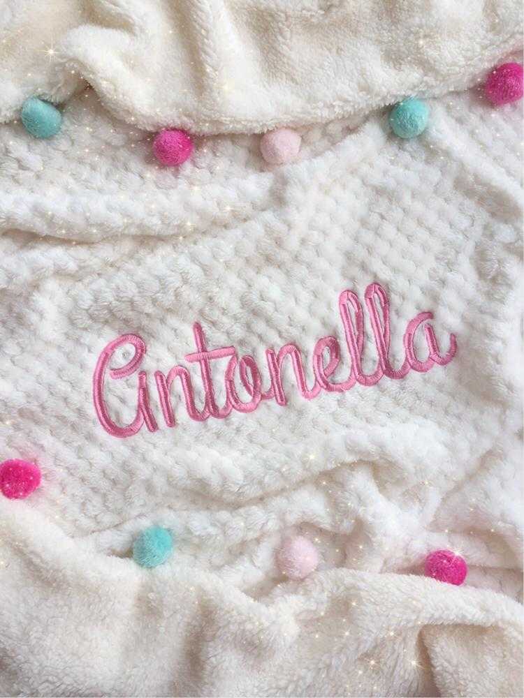 Cobija beige con pompones de colores